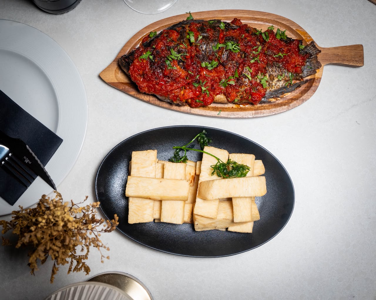Whole grilled fish in spiced tomato sauce with yam chips
