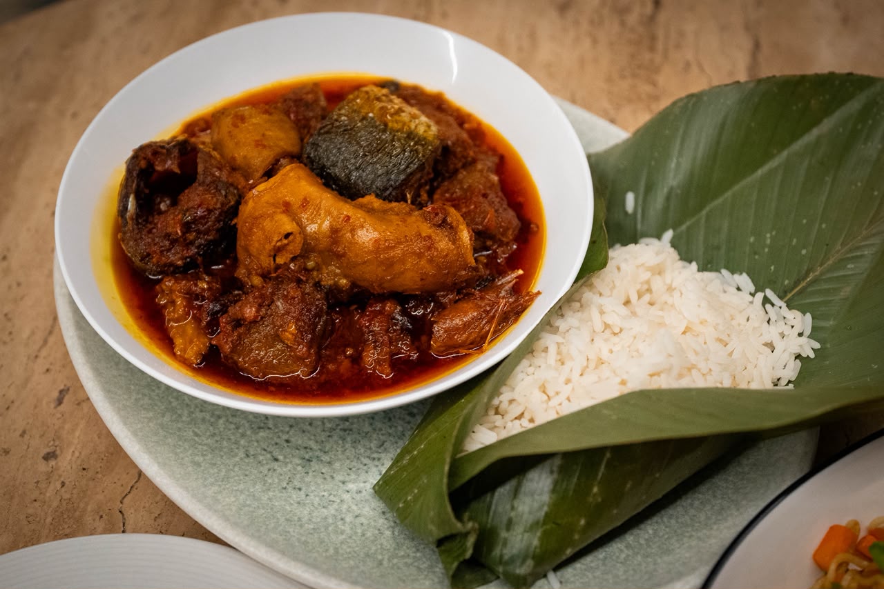 Pepper stew with assorted fish served with rice in banana leaf