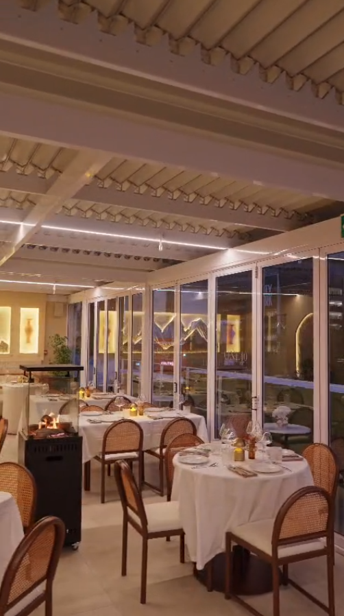 Candle-lit dining room with cane chairs and linen tables at ONE40vue